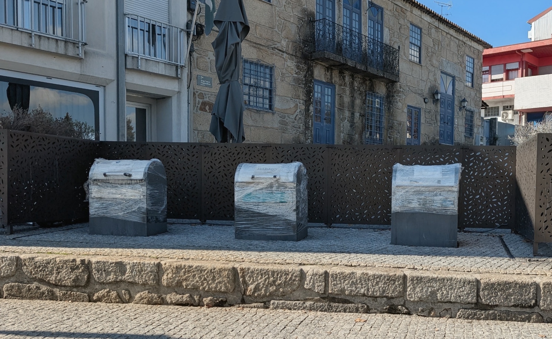 Três ecopontos envolvidos em película plástica no centro de Freamunde